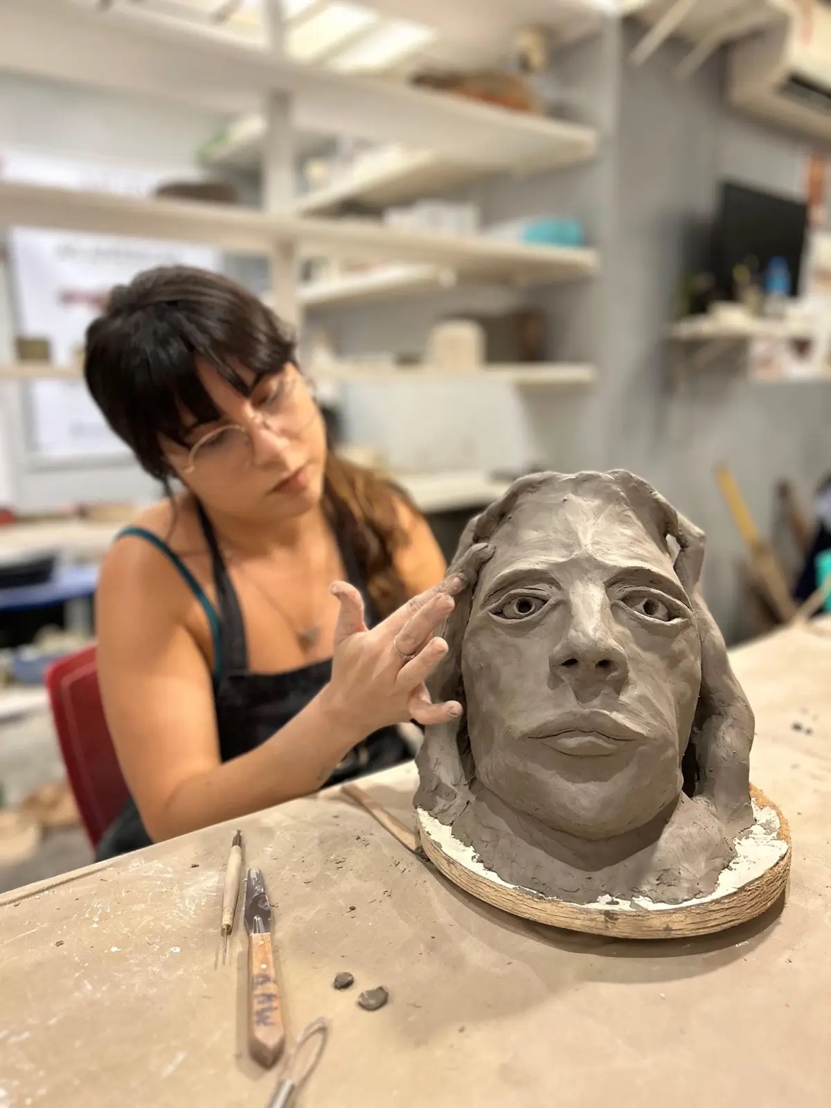 Una persona lavora a una scultura nella MUD Escola de Cerâmica